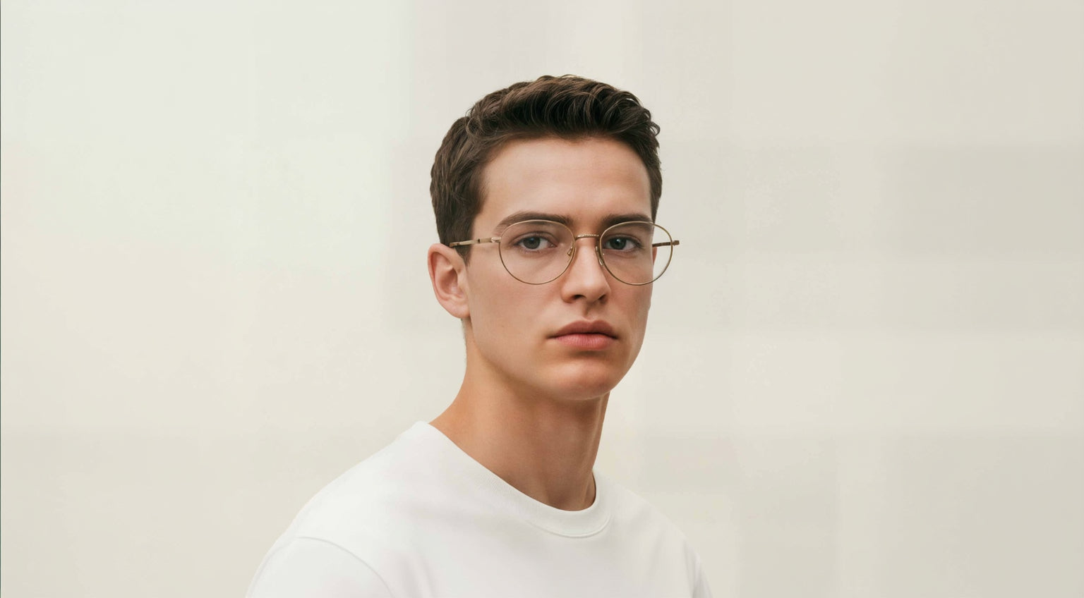 Man wearing Mokki reading glasses and a white shirt against a plain background