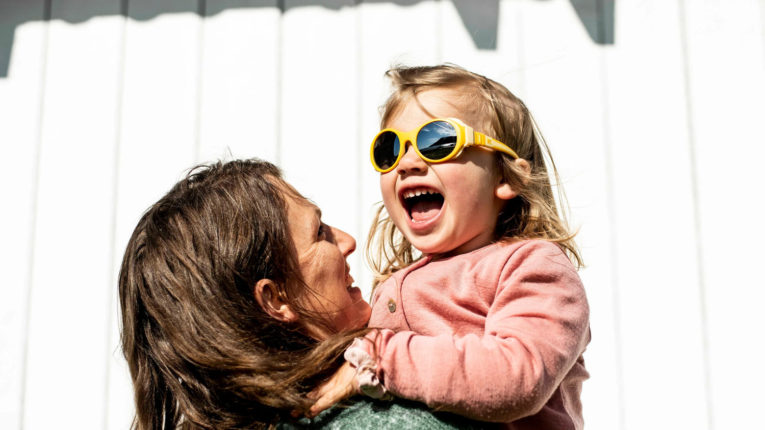 A girl is wearing Click & Change sunglasses for kids in yellow