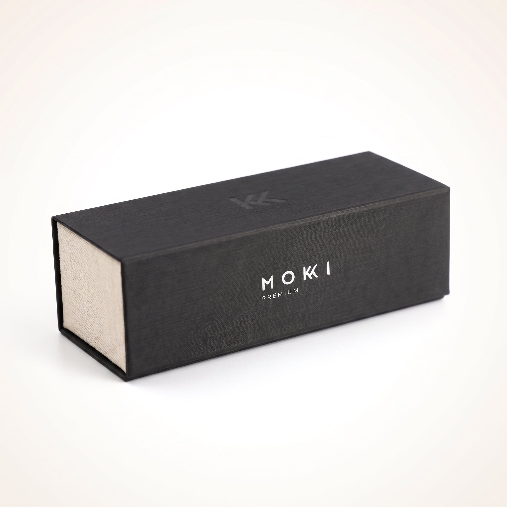 A rectangular protective hard case for sunglasses with a textured finish, featuring the brand name 'MOKKI PREMIUM', set against a clean white background.