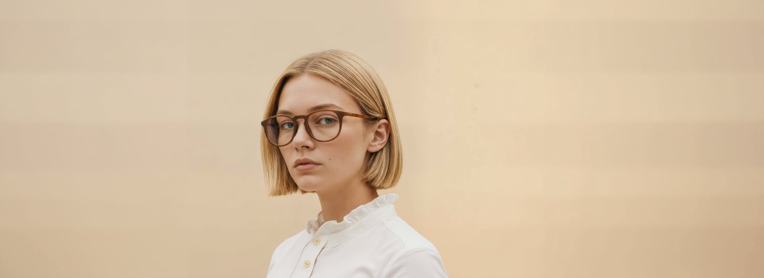 Woman wearing Mokki reading glasses and a white shirt against a beige background