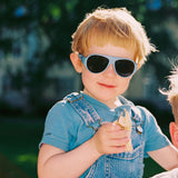 Child wearing Mokki Click & Change sunglasses and a denim outfit outdoors