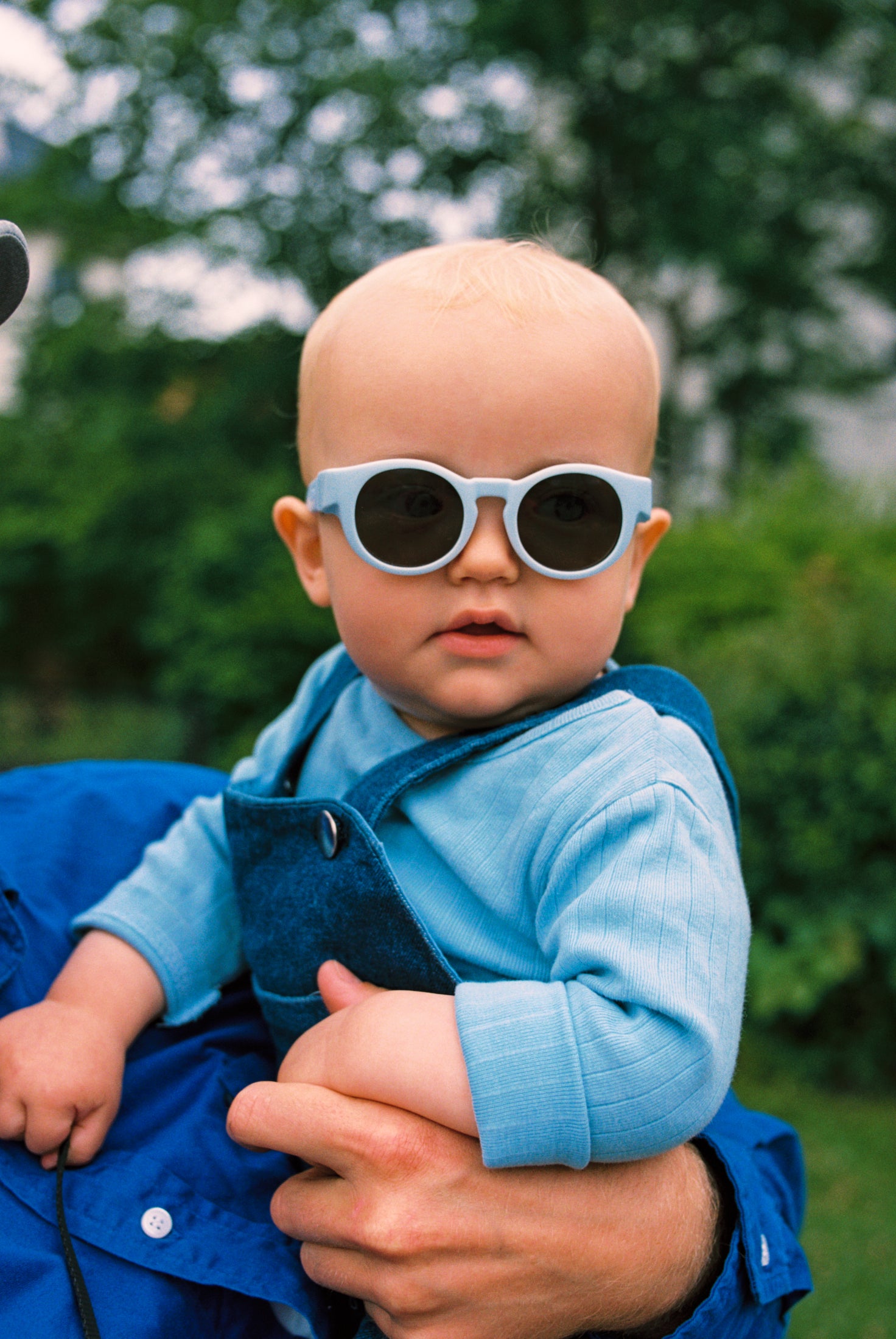 Baby wearing blue Mokki Click & Change sunglasses in 0-1