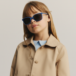 Ung jente med Mokki-solbriller for barn