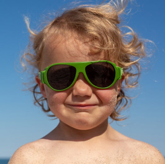A boy is wearing his green click & change sunglasses from Mokki