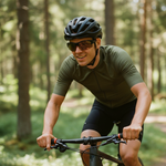 Mann som sykler på en skogssti